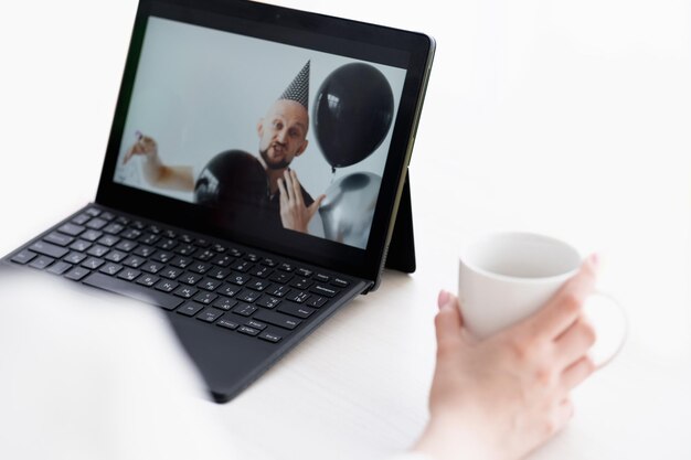 Virtual birthday online greeting quarantine lifestyle unrecognizable woman with cup of coffee lookin