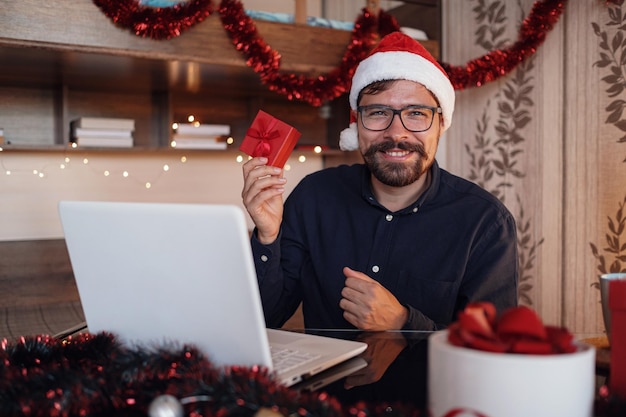 Virtual Christmas day house party Man smiling wearing Santa hat