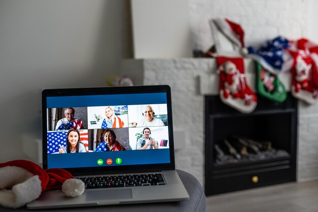 Virtual christmas tree meeting team teleworking. family video
call remote conference. laptop webcam screen view. team meet
working from their home offices. happy hour party online woman team
diversity