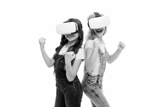 Foto concetto di educazione virtuale vita moderna interazione nello spazio virtuale cyber gaming tecnologia di realtà aumentata la realtà virtuale è eccitante ragazze bambini piccoli indossano occhiali vr sfondo bianco