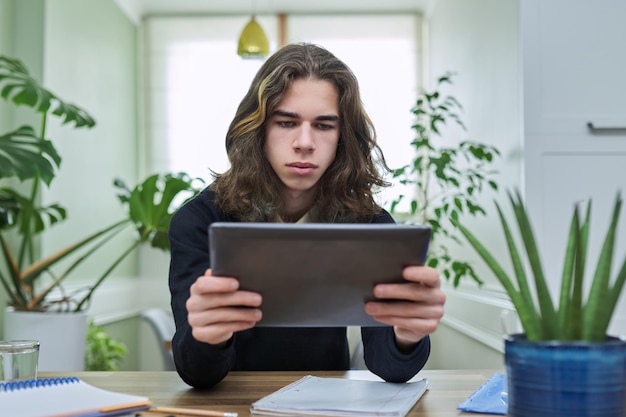 Virtual online lesson teenager guy learns remotely using\
digital tablet