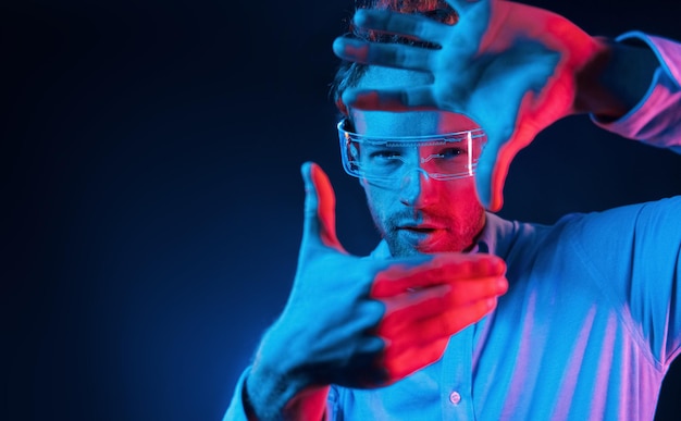 Virtual reality concept Neon lighting Young european man is in the dark studio