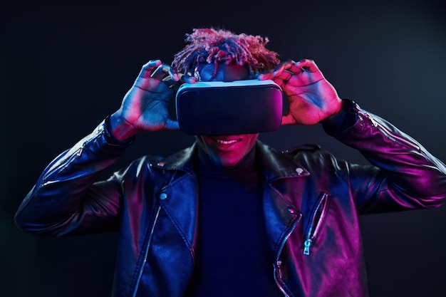 Virtual reality experience Futuristic neon lighting Young african american man in the studio