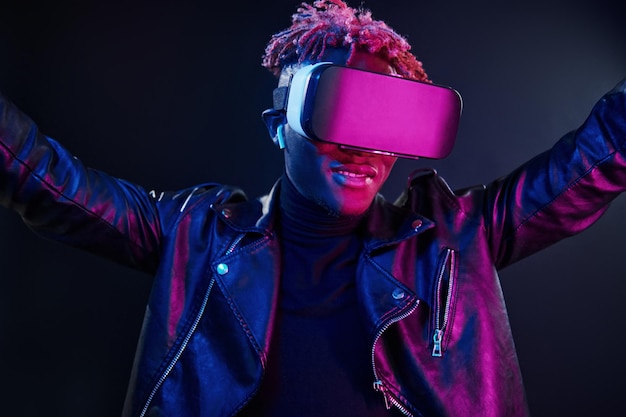 Virtual reality experience Futuristic neon lighting Young african american man in the studio