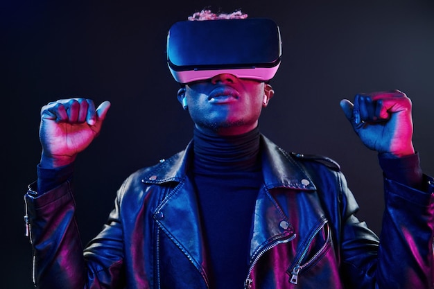 Virtual reality experience Futuristic neon lighting Young african american man in the studio