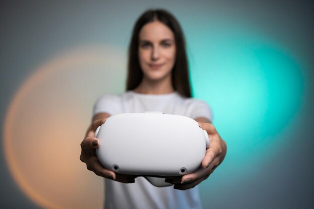 Virtual reality glasses in woman hand on the colorful background. Future technology, VR concept