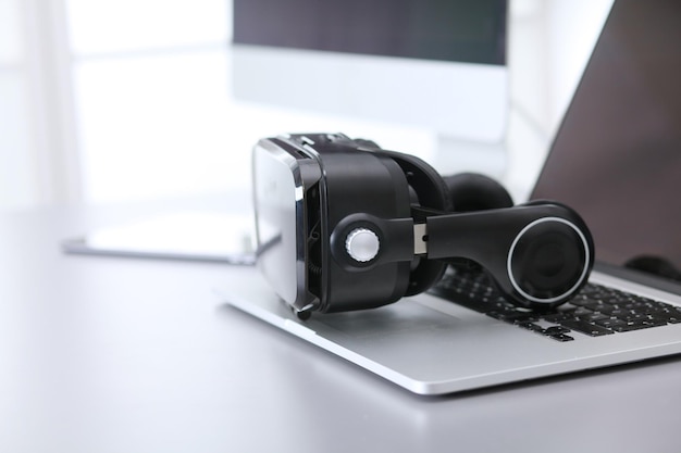 Photo virtual reality goggles on desk with laptop business 3d technology