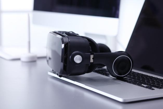 Photo virtual reality goggles on desk with laptop