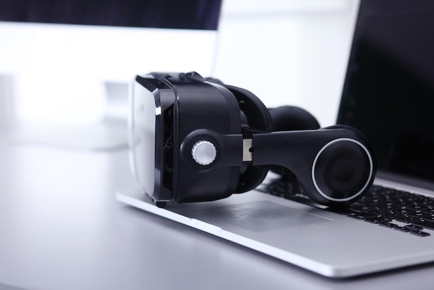Virtual reality goggles on desk with laptop