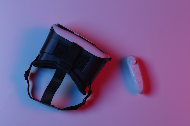 Virtual reality headset en joystick in rood blauw gradiënt neonlicht. Bovenaanzicht