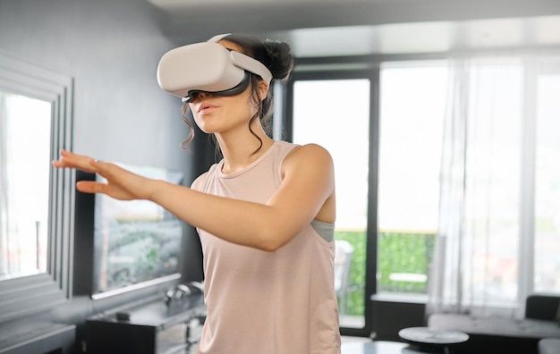 Virtual reality metaverse and technology with a woman in the living room of her home using a headset to access a 3d game Futuristic VR and gaming with a female gamer using ai to play games