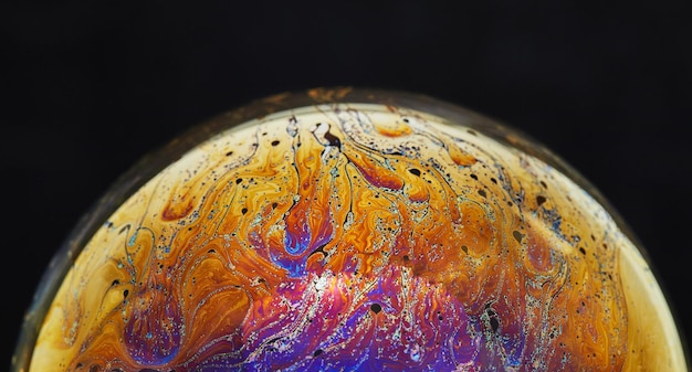 Virtual reality space with abstract multicolor psychedelic planet Closeup Soap bubble like an alien planet on black background