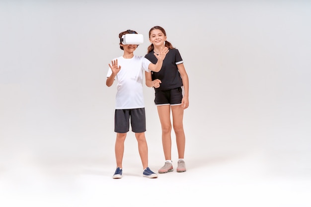 Virtual reality and sport two excited teenage boy wearing d glasses and cute girl standing isolated