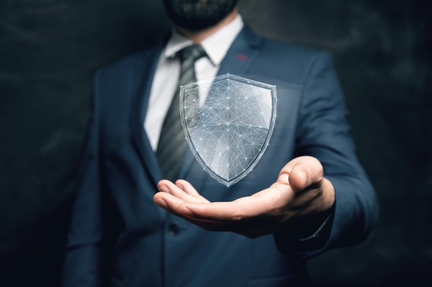 Virtual shield from the network cyber security concept man holding in his hand