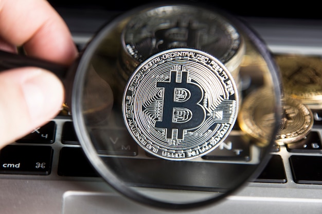 Virtueel geld zilveren bitcoin onder een vergrootglas