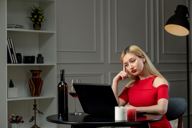 Virtueel liefdes schattig blond meisje in rode jurk op afstandsdatum met wijndenken