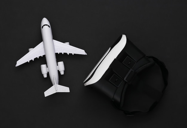 Virtueel reizen. Virtual reality-headset met vliegtuig op zwarte achtergrond. Bovenaanzicht