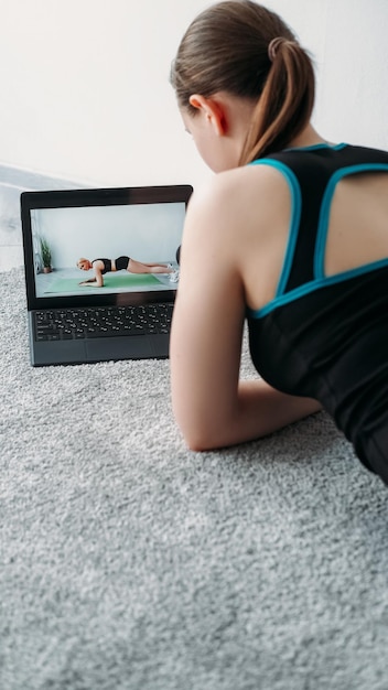 Virtuele fitnesscursus online training workout tutorial vrouw kijkt naar sport video programma op laptop