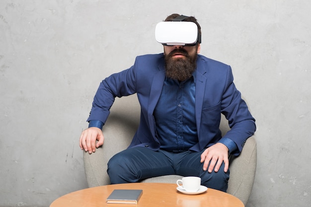 Virtuele kantoor- en werkruimte. Zakenman zit stoel slijtage hmd verkennen virtual reality of ar. Zakenpartner interactie in virtual reality. Nieuwe kans. Business implementeren moderne technologie.