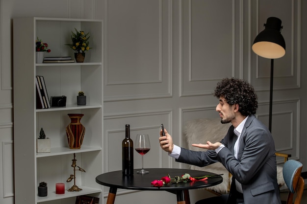 Virtuele liefde knappe schattige kerel in pak met wijn op een afstand telefoondatum kusjes sturen