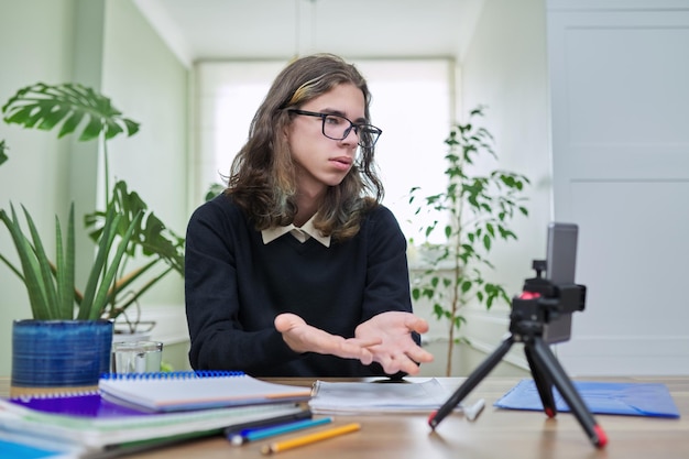 Virtuele online les tienerjongen leert op afstand met behulp van een smartphone