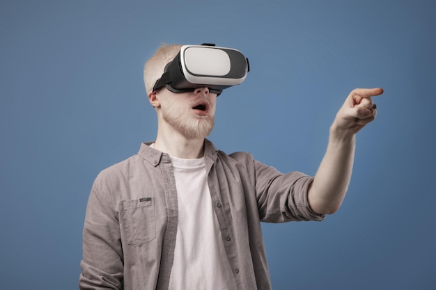 Virtuele wereld in d-simulatie opgewonden albino-man in vr-bril die speelt en iets probeert aan te raken