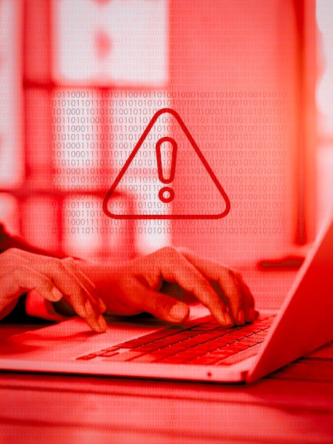 Foto avviso virus triangolo rosso sistema hacked errore segno malware attenzione pericolo simbolo avviso che mostra sul codice binario mentre uomo d'affari che lavora con computer portatile tono rosso stile verticale