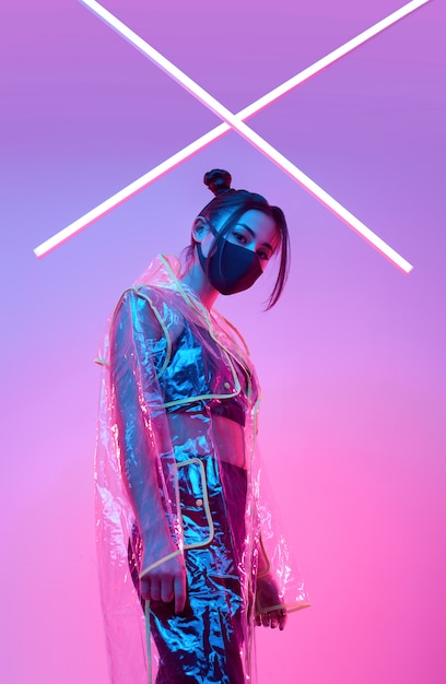 Foto maschera virus donna asiatica che indossa una protezione per il viso intorno al neon colorato