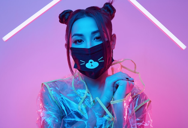 Virus mask Asian woman wearing face protection around colorful neon