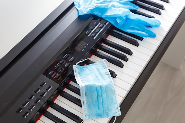 바이러스 보호 마스크와 장갑이 피아노 위에 놓여 있다