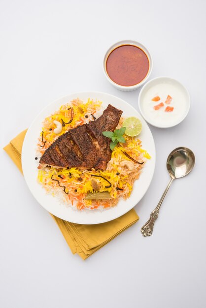 Vis Biryani of visrijst - populair Indiaas niet-vegetarisch recept gemaakt van vis gemarineerd met Indiase kruiden, verse kruiden en gekookt met basmatirijst, selectieve focus