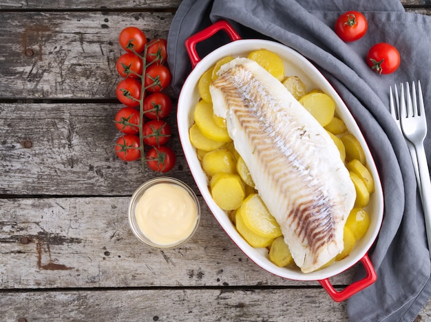 Vis kabeljauw gebakken in de oven met aardappelen. bovenaanzicht, kopie ruimte.