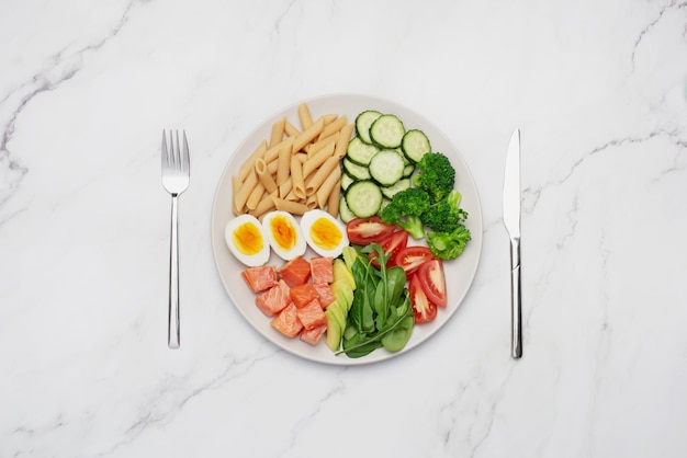 Vis met pasta ei en avocado in een grijze plaat op een grijze achtergrond Gezonde voeding Recept Lunchtijd