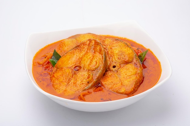 Viscurry_Seer viscurry, traditionele Indiase viscurry, kerala speciaal gerecht, gerangschikt in een witte kom gegarneerd met kerriebladeren op witte achtergrond