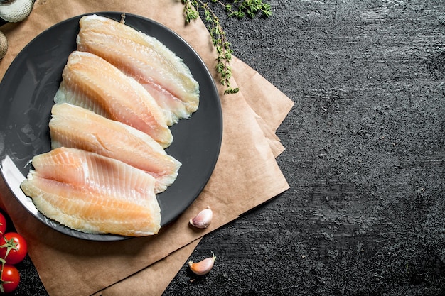 Visfilet op bord met papieren tijm en knoflookteentjes