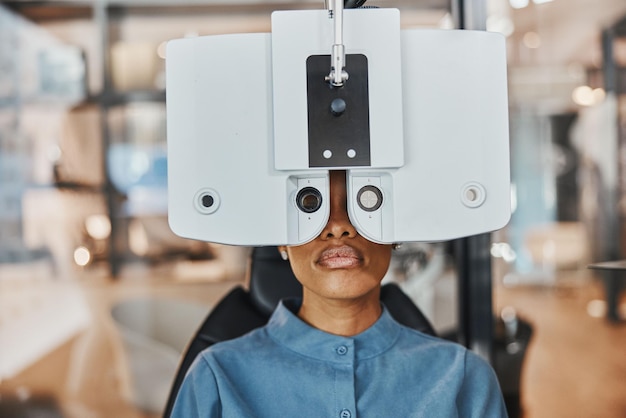 Foto visie oogonderzoek en zwarte vrouw in optometriekliniek voor het testen van gezichtsvermogen en optische beoordeling gezondheidszorg optometrist overleg en patiënt met medische apparatuur phoropter en lens voor ogen