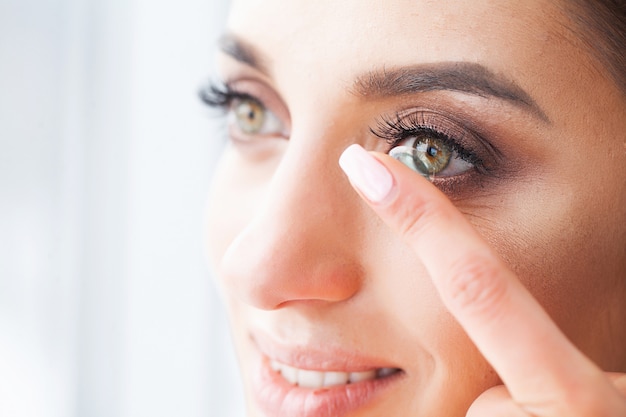 Vision concept. Close-up shot of young woman wearing contact lens