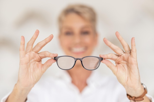 Vision eyesight and glasses in hands with blur woman has poor eye sight holding spectacles in blurred background Healthcare medical insurance and eyes prescription lens in clear spectacle frames