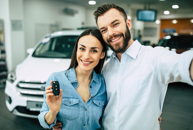 Visit the dealership Happy young couple chooses and buying a new car for the family