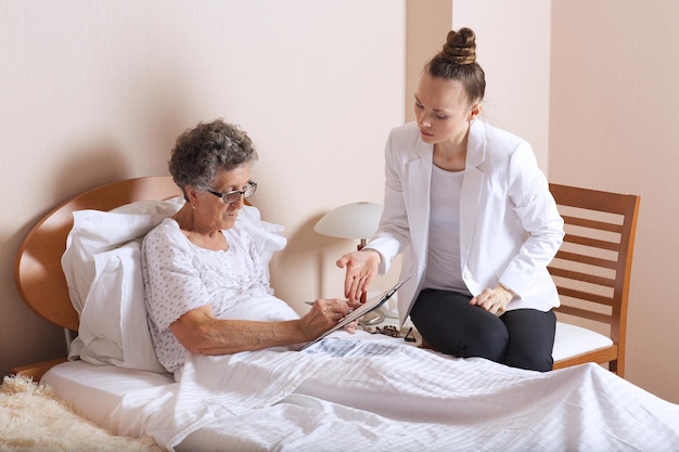 Visit of senior social work assistant to an old woman