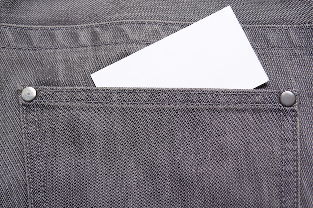 Visitekaartje in achterzak van oude grijze spijkerbroek