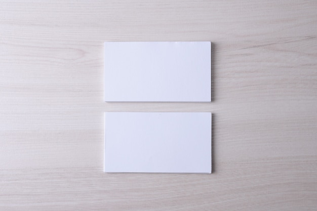 Visitekaartje leeg op houten achtergrond. Corporate briefpapier, merkmodel. Creatief designbureau. Plat leggen. Kopieer ruimte voor tekst. Sjabloon voor ID.