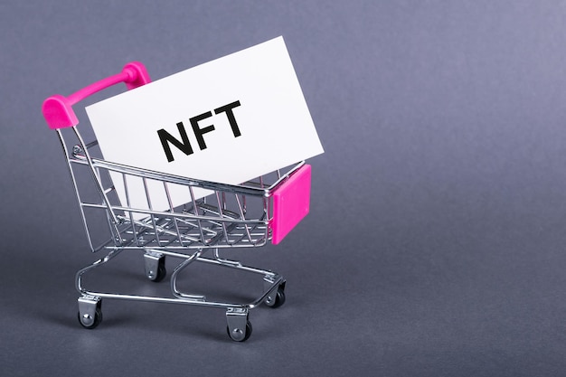 Visitekaartje met de letters NFT in winkelwagen bedrijfsconcept