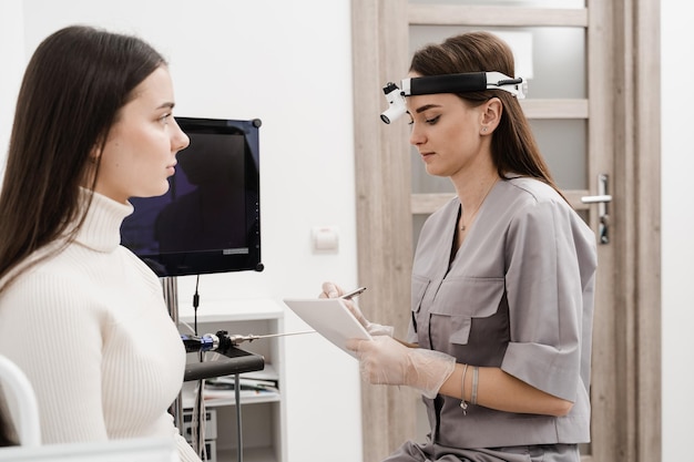 Visiting ENT doctor for examination of the state of health of the ear throat and nose Consultation of woman with otolaryngologist in a medical clinic