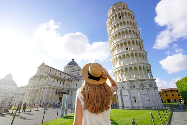 Visitando la torre pendente di pisa famoso punto di riferimento d'italia giovane viaggiatore donna in piazza del duomo a pisa toscana italia