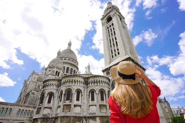 Visiting Paris France Tourist woman in Paris with the Basilica of the Sacred Heart SacreCoeur of Paris Low angle