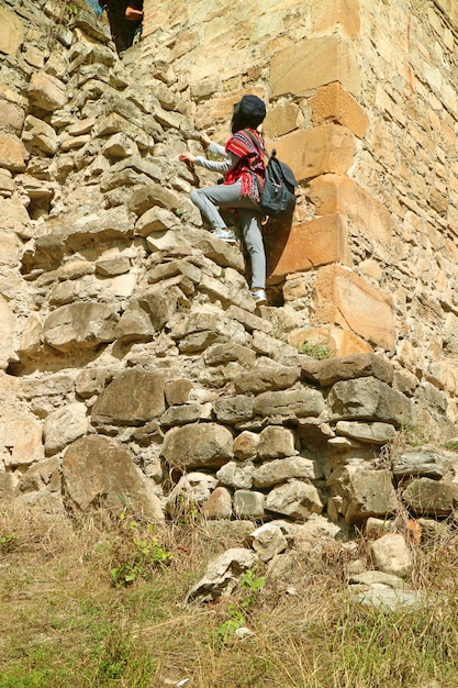 Visitor climbing up to the Sheupovari tower inside the Ananuri medieval castle complex, Georgia