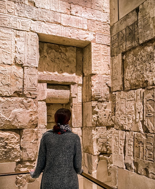 Visitor looking on Egyptian hieroglyphs on the wall in Egyptuian museum in city Berlin at Germany