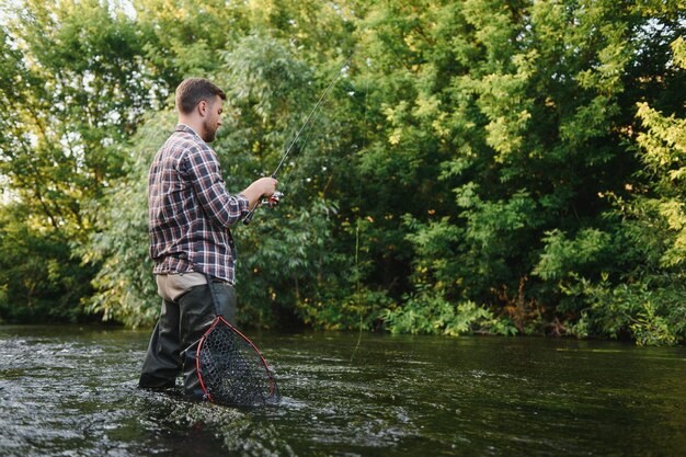 Vissen visser en forel visser op wilde rivier