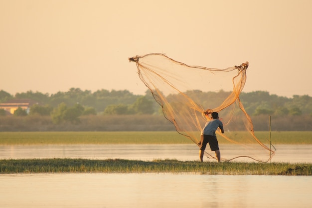 Visser die een net in het meer werpt